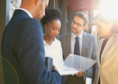 Shot of a diverse group of businesspeople having a meeting on a balcony in bright sunlight